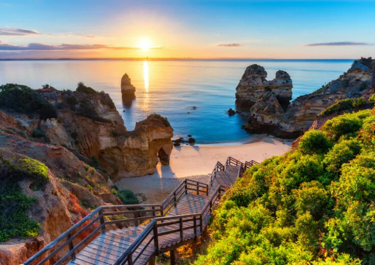 Algarve, Portugal mit türkisfarbenem Meer im Hintergrund. Holzsteg zum Strand Praia do Camilo, Portugal.