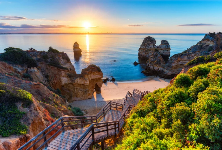 Algarve, Portugal mit türkisfarbenem Meer im Hintergrund. Holzsteg zum Strand Praia do Camilo, Portugal.