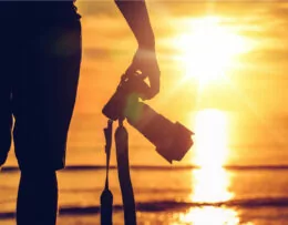 fotograaf op strand bij zonsondergang