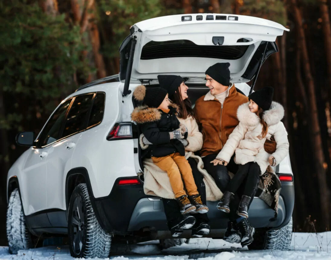 Familie op reis met kinderen in de winter bij de auto