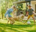 Kinderen spelen met hond in tuin