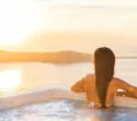 Luxe wellness, vrouw ontspannen in de hot tub kijken naar zonsondergang