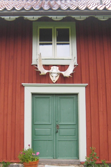SE-61040-02_Een gewei van een eland boven de entree van de Zweedse villa Narebo Gård Jaktflygel_2_Zweden_Belvilla
