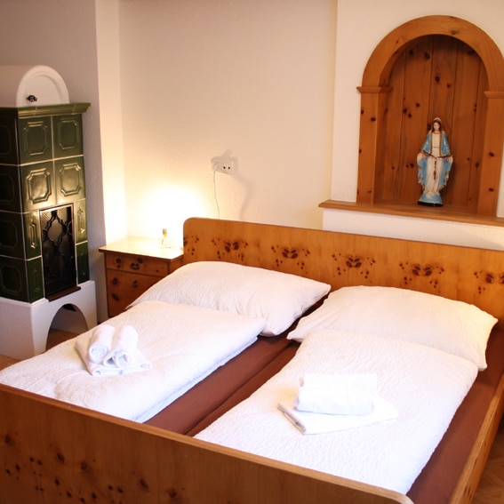 Slapen onder het toeziend oog van Maria en met de warmte van een tegelkachel AT-5732-11_Huber_tegelkachel_heiligenbeeld_Oostenrijk_Belvilla vakantiehuizen