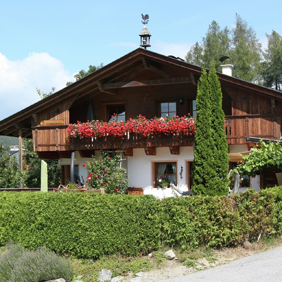 's Zomers sieren bloembakken vol geraniums de vakantiewoning Prinoth (en een torentje op het dak) AT-6142-03_Prinoth_geraniums_beltoren_Oostenrijk_Belvilla vakantiehuizen